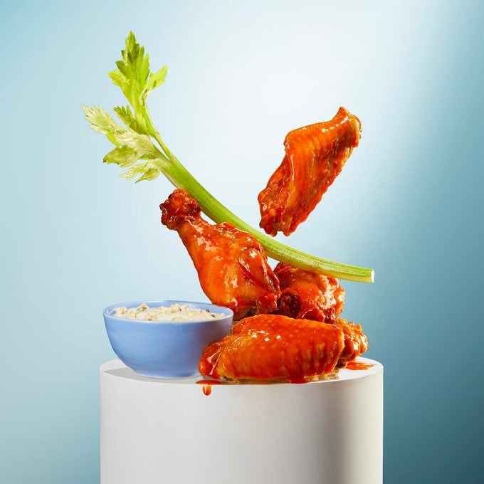 Buffalo wings with ranch and celery on a pedestal
