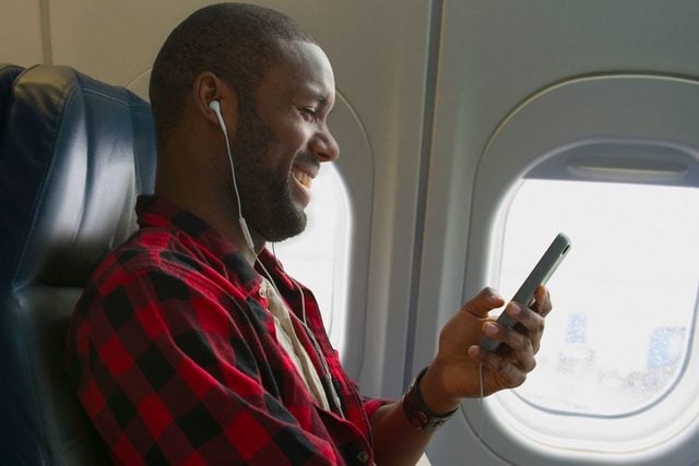 Black Man Listening To Earbuds On Airplane