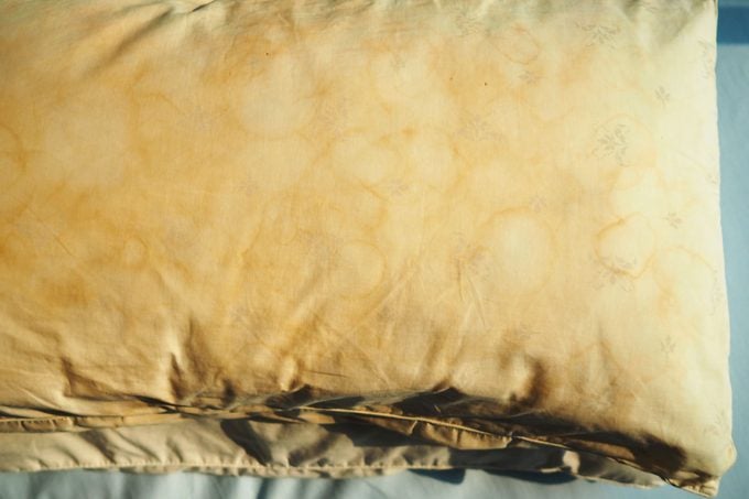 Dirty Pillow With Pale Yellow And Brown Color From Saliva Stain On Bed