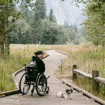 female in wheelchair traveling through Yosemite with dog