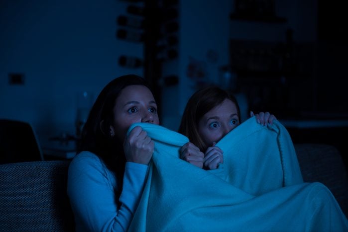 Two women watching tv together, horror movie