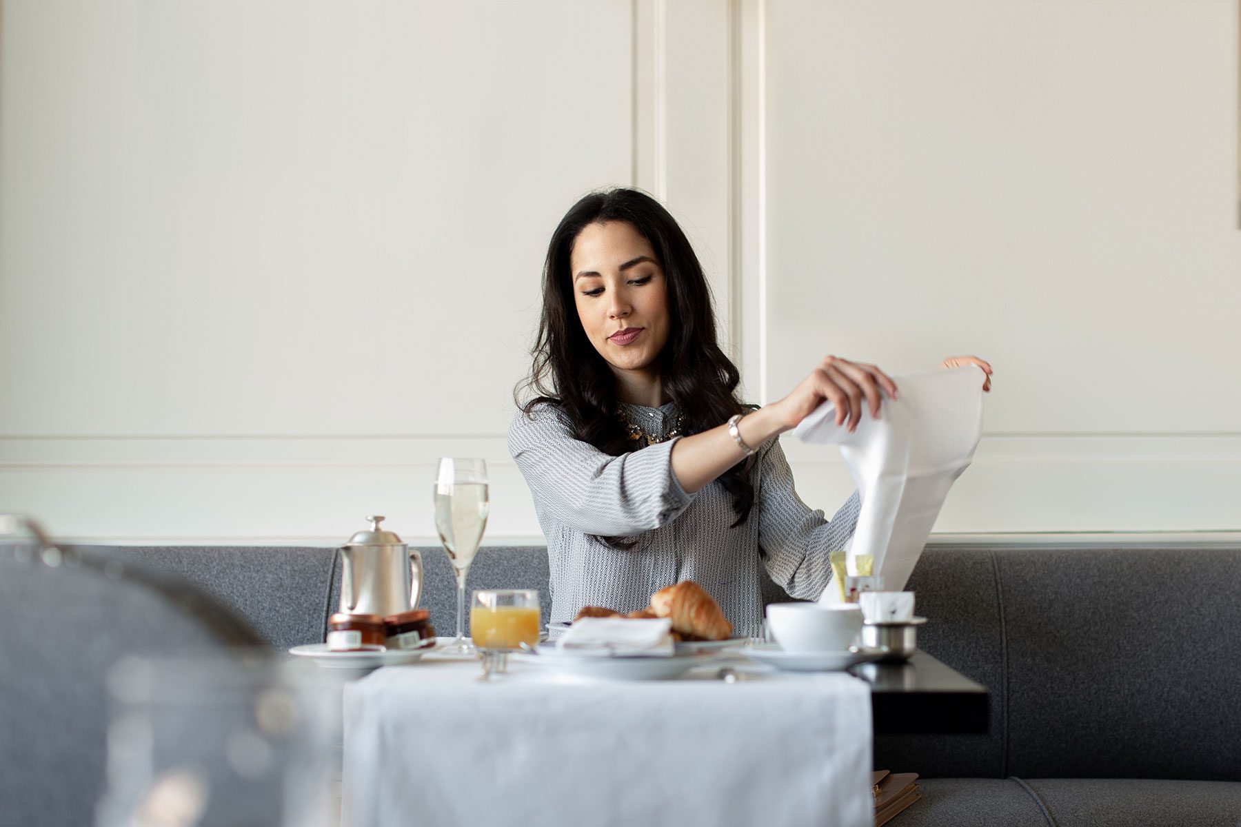 Woman setting napkin before having food at table