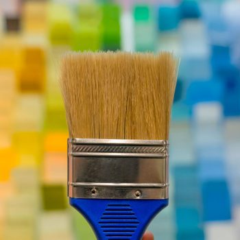 Paintbrush in from of a background of paint chips in a home improvement store