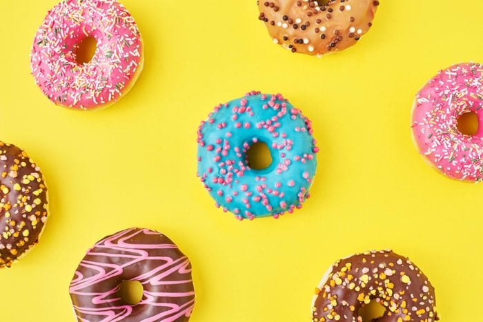 Color donut pattern on a yellow background, top view flat lay