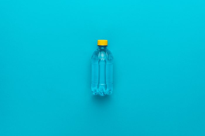 Water bottle with yellow cap on the blue background