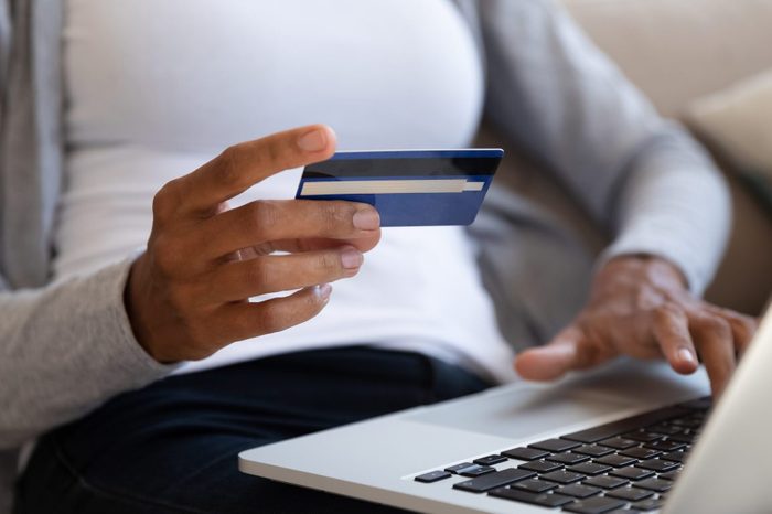 African American woman shopping online using credit card