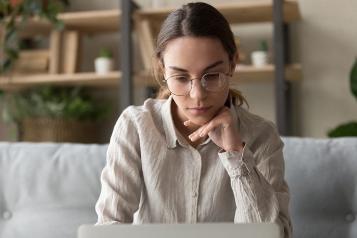Focused thoughtful female freelancer working on laptop