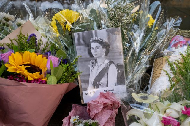 A photograph of Queen Elizabeth II surrounded by flower bouquets is seen outside the British Consulate General after the passing of the former Queen. Queen Elizabeth II, the UK's longest-serving monarch, has died at Balmoral aged 96, after reigning for 70 years. 