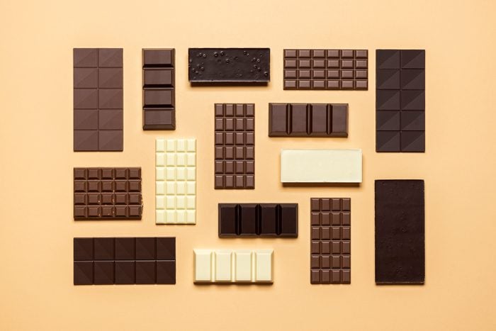 Chocolate bar assortment isolated on yellow background. Assorted chocolate creative layout