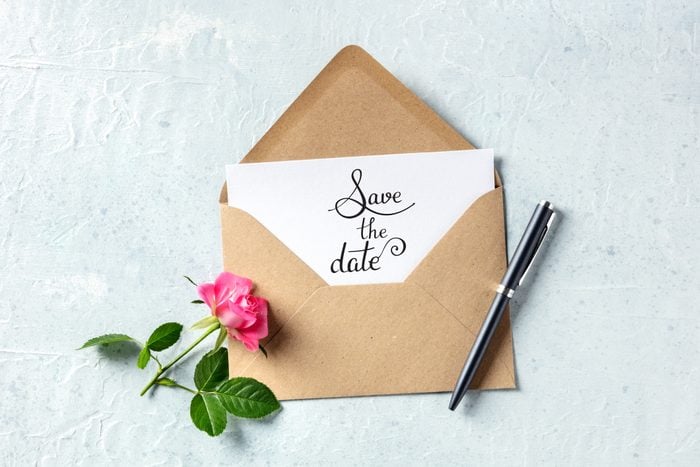 Save the date lettering on an invitation in a brown kraft envelope, shot from above