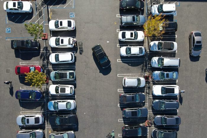 Aerial top view of parking lot with with varieties of colored vehicles