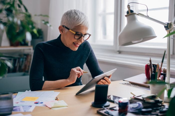 Female Designer Working on a Project at the Desk of her Office wearing turtleneck