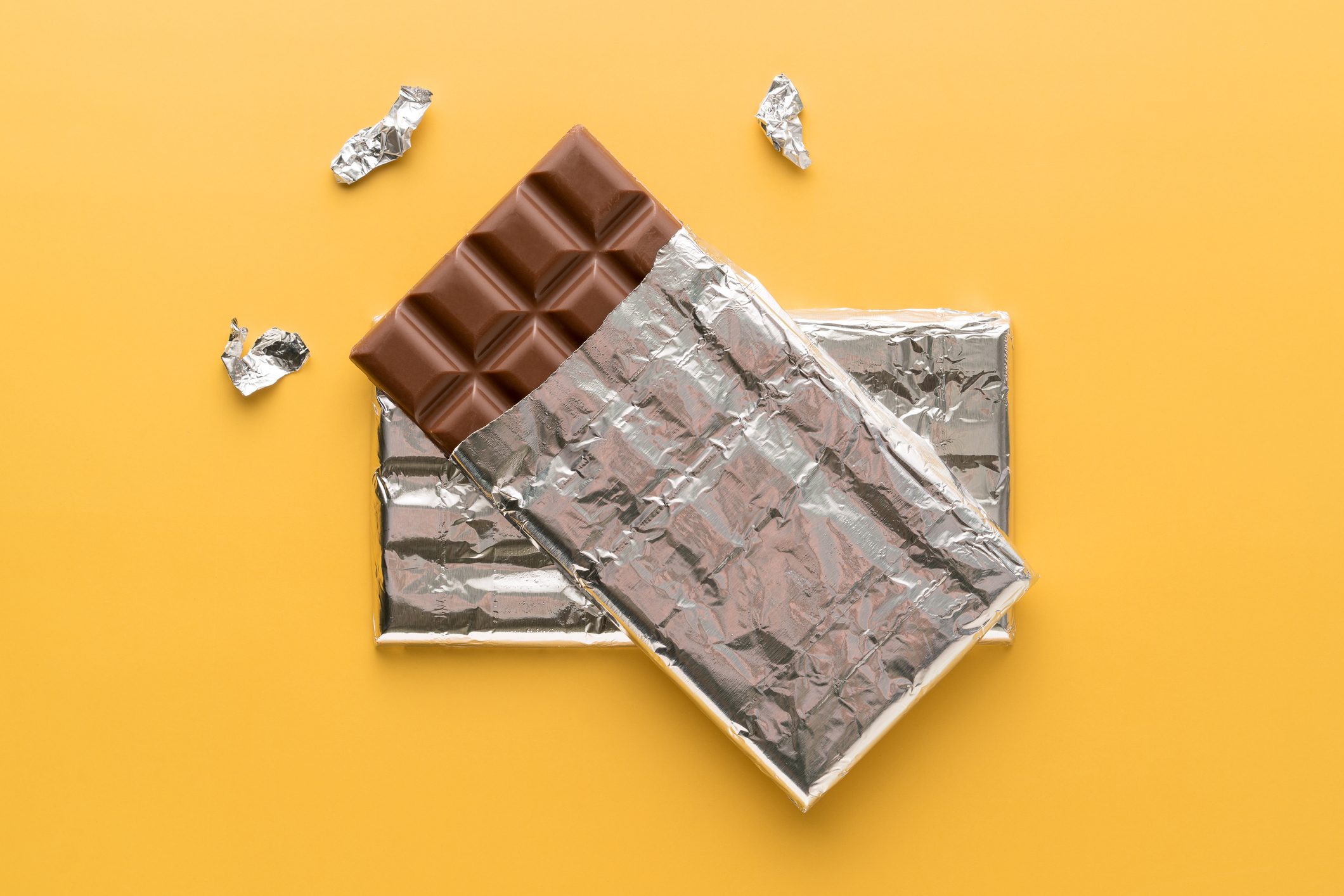 Chocolate Bar in silver wrapping on a yellow background