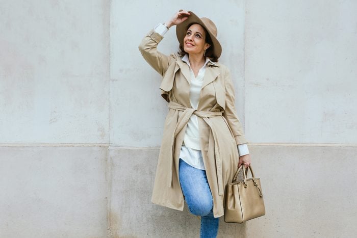 Woman in stylish Trench Coat posing in the street