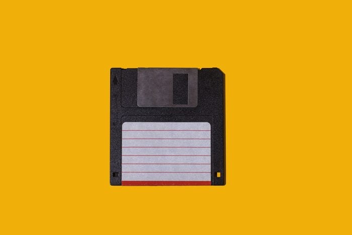 Black retro 3.5" floppy diskette with white and red label on yellow background. Concept of computing, computer, storage, vintage, disk and data storage.