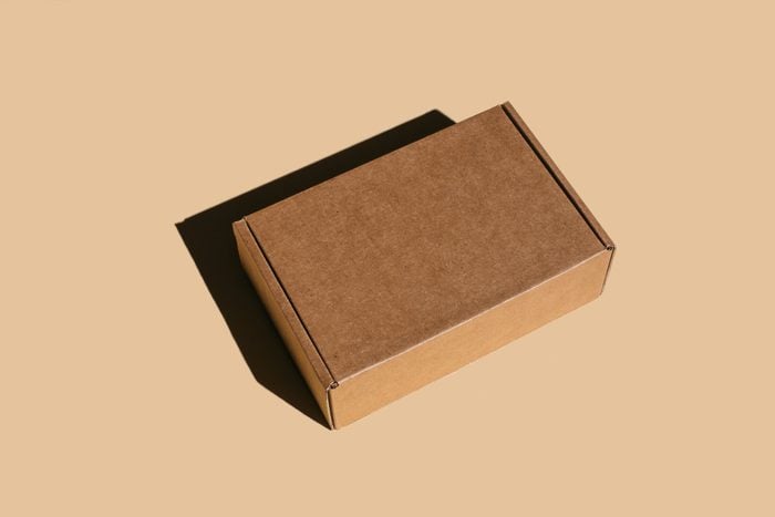 Brown cardboard box on beige background.
