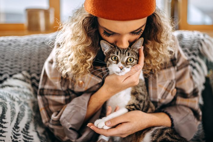 Close up shot of young woman kissing with her cat