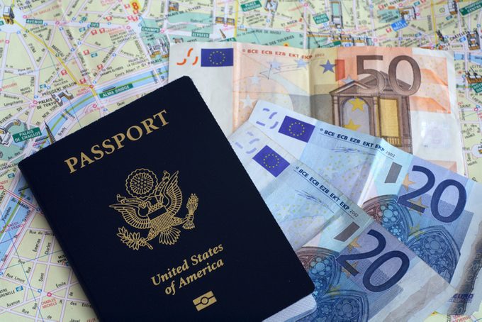 US passport and Euros on French map