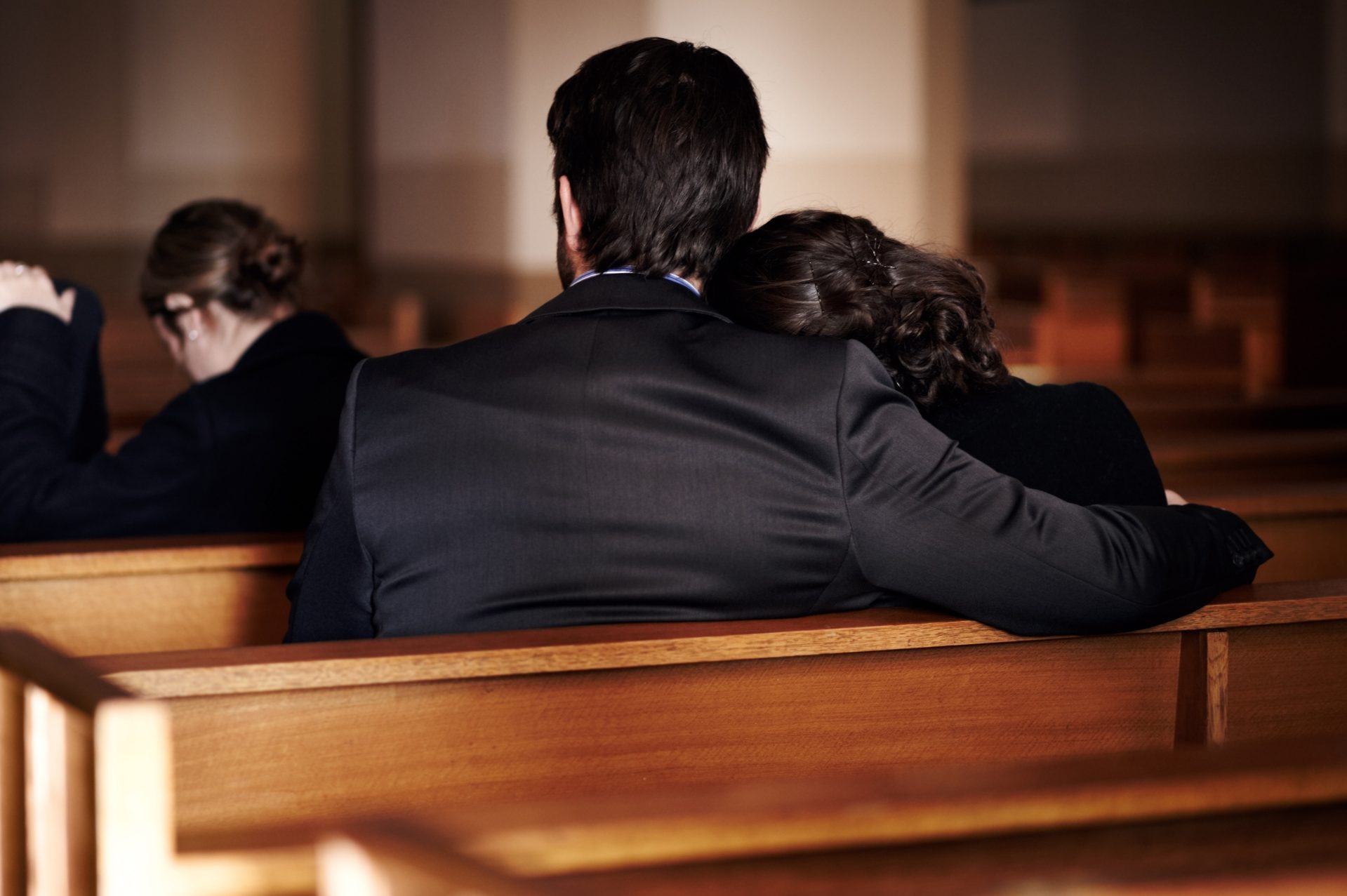 two people sitting at church during a funeral