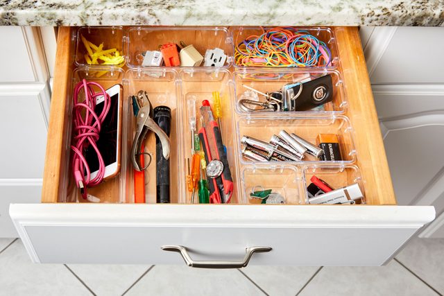 open junk drawer with items organized in clear bins