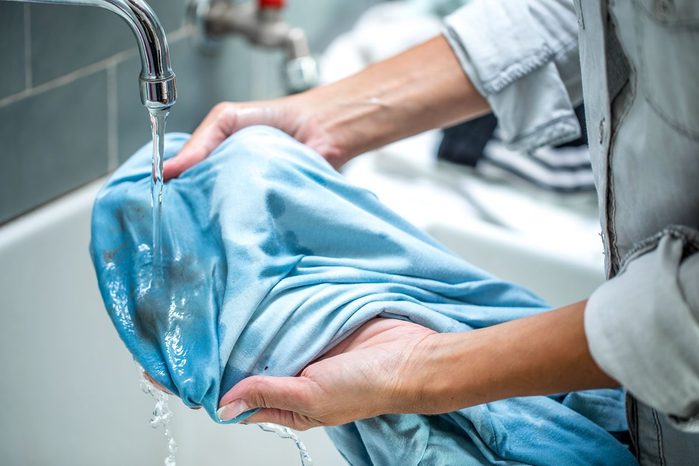 Woman Cleaning Stained Shirt In Bathroom Sink 2