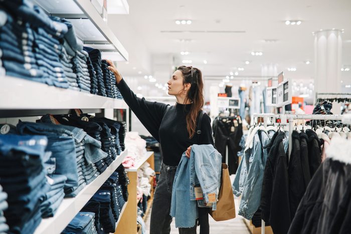 Woman Shopping Denim Jeans In A Clothing Store