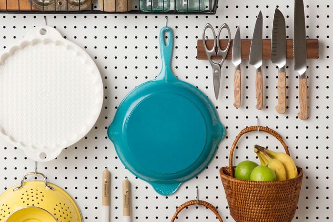 cookware on a Peg Board for Kitchen Organization accent wall.