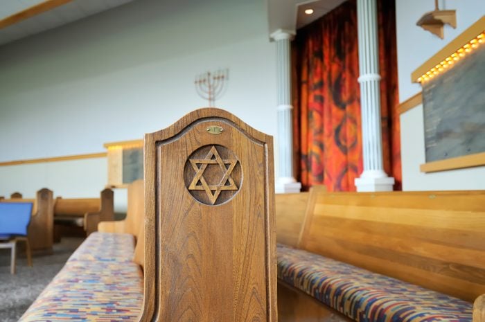 interior of a jewish temple with a star of david carved in the wood at the end of the bench