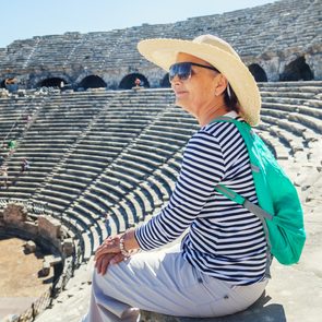 Mature woman sits on the steps of the monuments of Greece