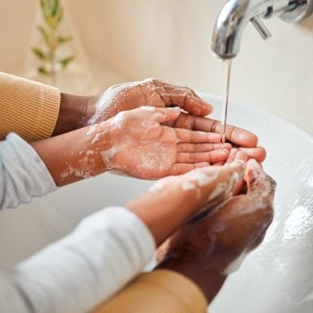 People cleaning hands, soap and skincare with hygiene in bathroom, self care with skin and water for wash. Parent helping child, clean with quality time together and family home, health and wellness