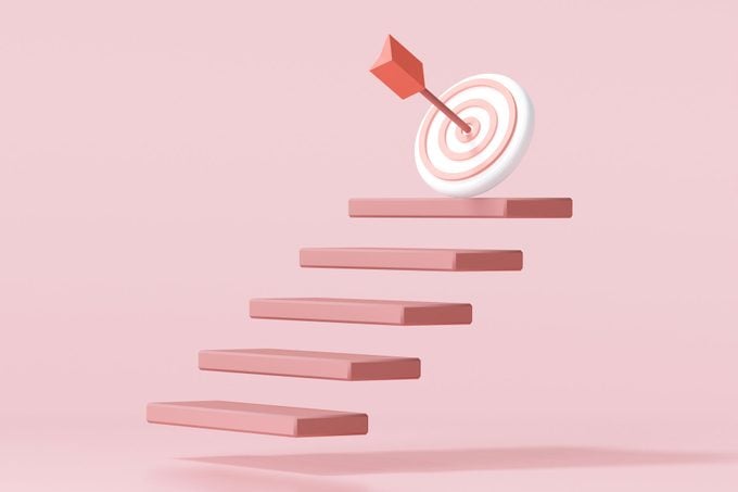 Red Arrow Hit The Center Of Target On Top Of The Staircase on pink background