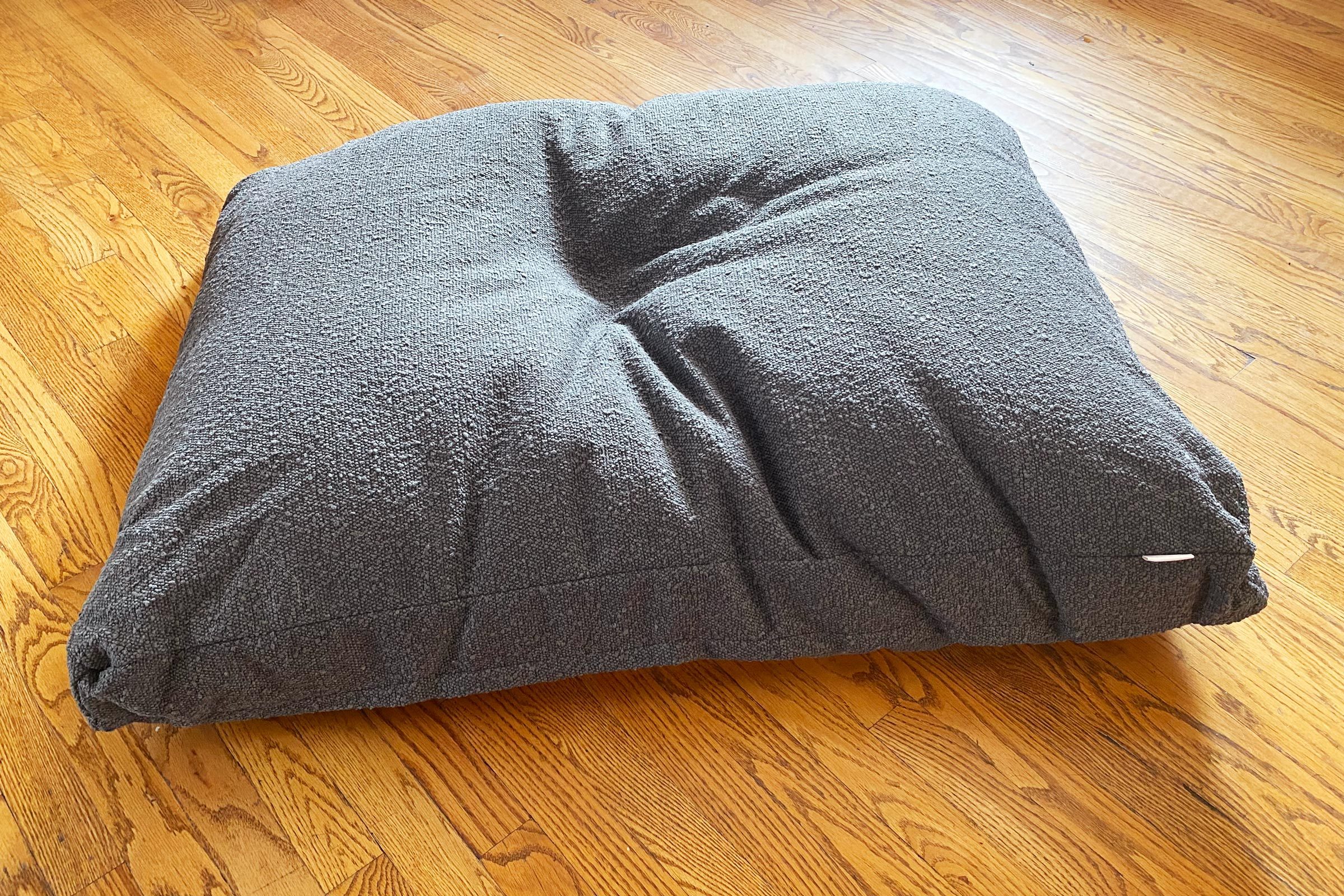 grey saatva dog bed on a wooden floor