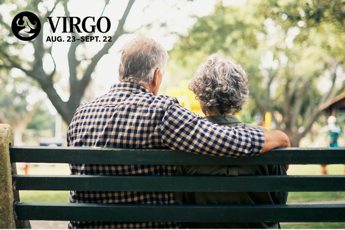 mature couple sitting on a park bench people watching