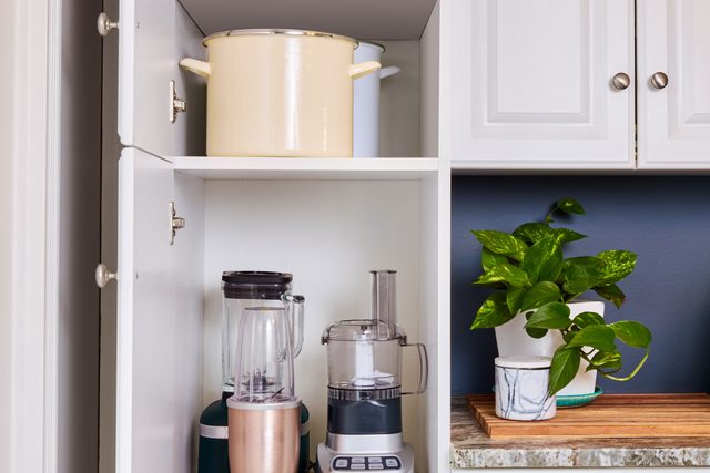 tall pot in cabinet near small, tall appliances