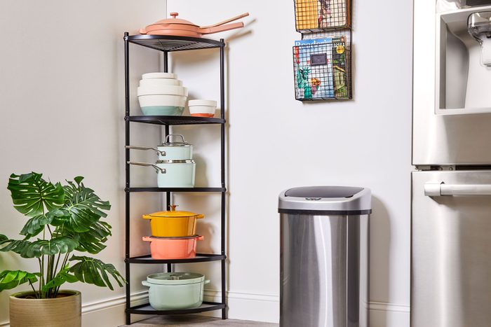 standing rack with colorful pots and pans in a corner in a kitchen setting