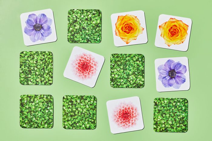 memory card game tiles featuring flowers are arranged on green background