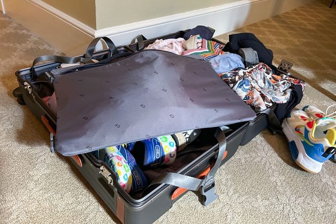 Suitcase filled with clothes, shoes and other materials