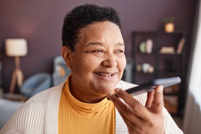 Senior Woman Recording Voice Message To Family on her smartphone