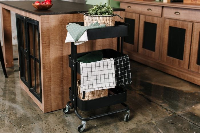 Cozy loft kitchen with dinning table, chairs and metal storage racks on wheels - trolley