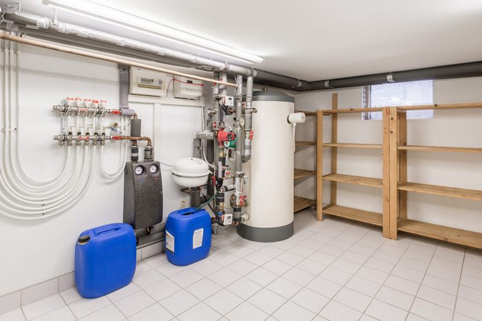 Basement with water heater, pipes and wooden shelves