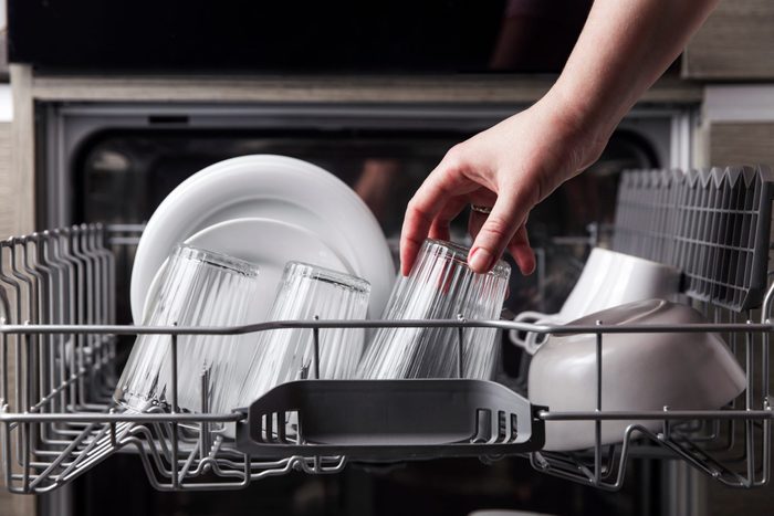 Open Dishwasher With Clean Cutlery Glasses Dishes Inside In The Home Kitchen