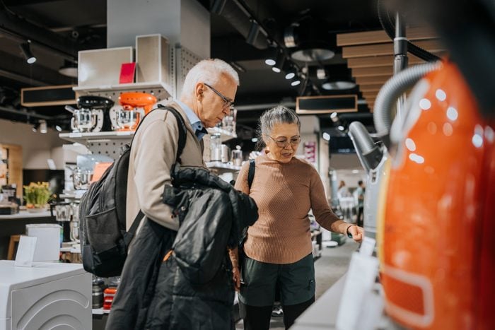 Elderly couple examining appliances while shopping