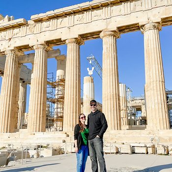 A Couple Standing In Front Of Parthenon Athens Greece