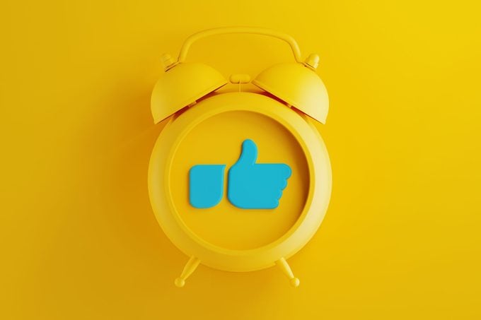 Yellow Alarm Clock with Thumbs Up Icon on Yellow Background