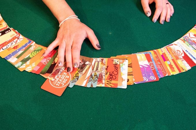 hand with a bunch of gift cards spread out on a table