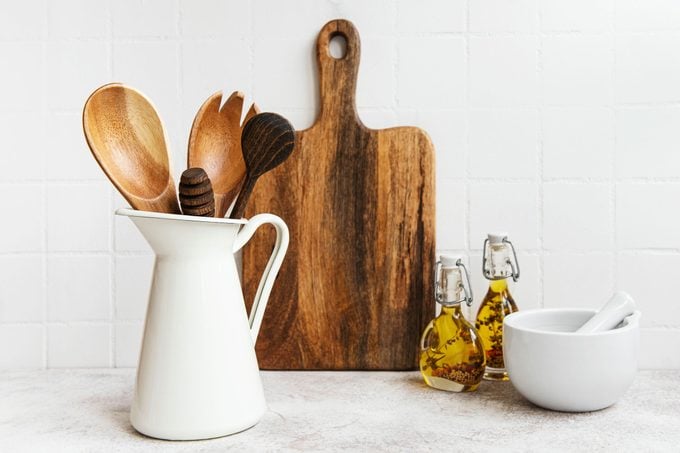 Kitchen utensils, tools and dishware on on the background white tile wall.