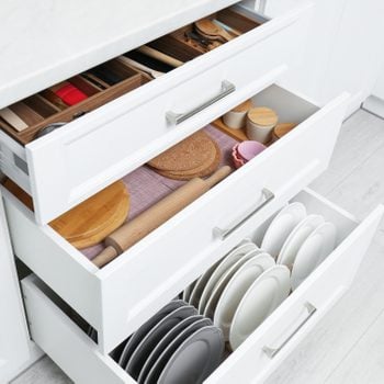 Open drawers with cutlery and utensils indoors. Order in kitchen