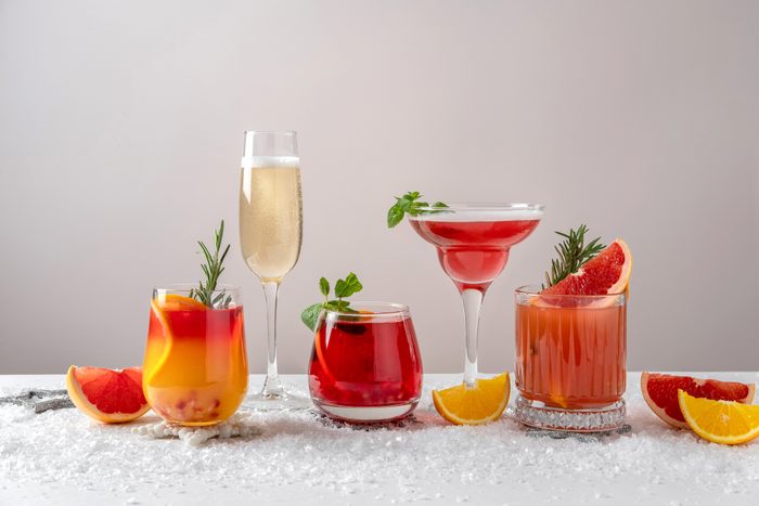 Festive cocktails with various citrus. Assortment of alcohol Christmas drinks. Pink and red sangria cocktails, champagne, pomegranate jingle and citrus tequila smash.