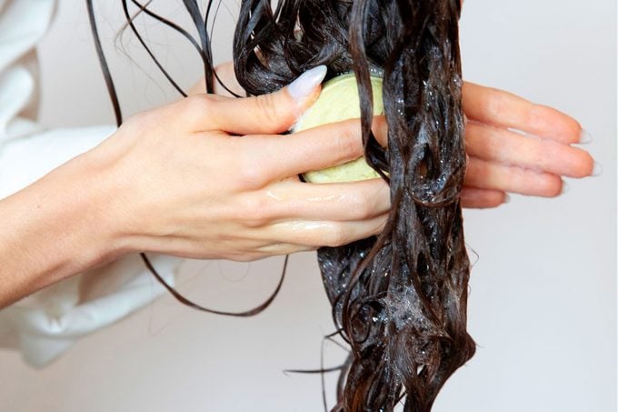 woman washing long brown hair with a shampoo bar