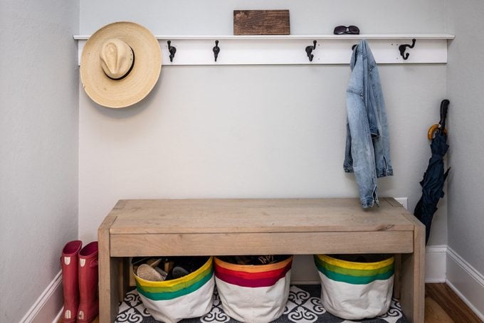 A small entrance mudroom with a hooks for hanging jackets and hats and organization which connects the garage to the house in a new construction home